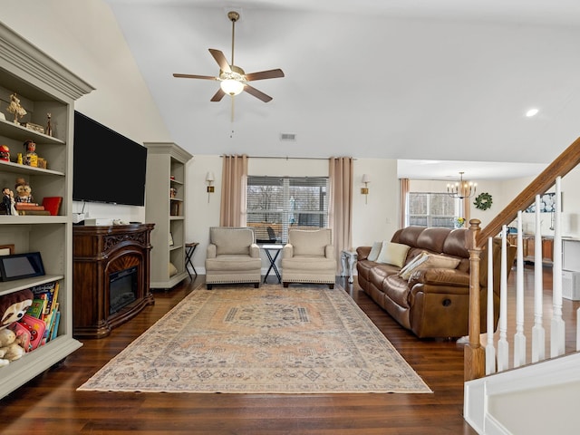 living room featuring built in shelves, lofted ceiling, dark hardwood / wood-style floors, and ceiling fan with notable chandelier