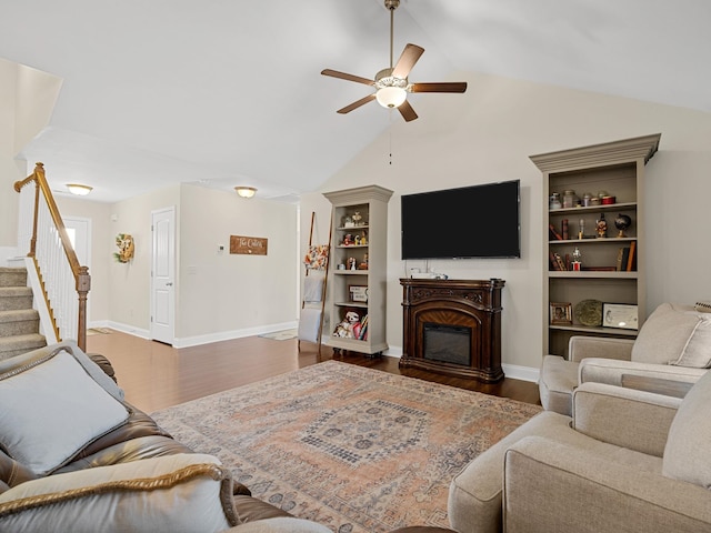 living room with dark wood-type flooring, ceiling fan, vaulted ceiling, and built in features