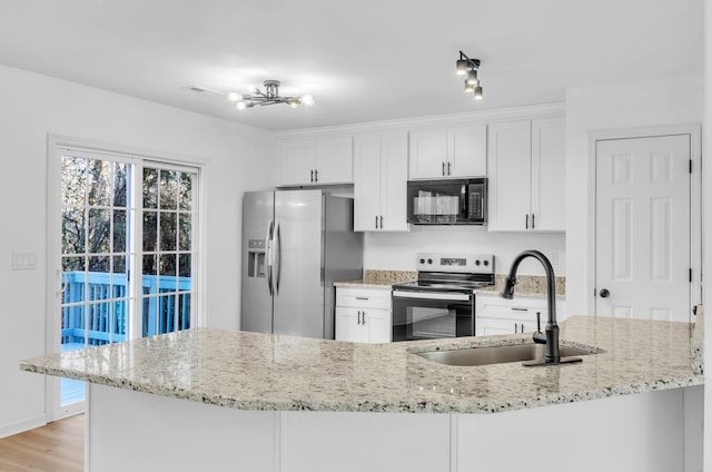 kitchen featuring sink, white cabinetry, light wood-type flooring, stainless steel appliances, and light stone countertops