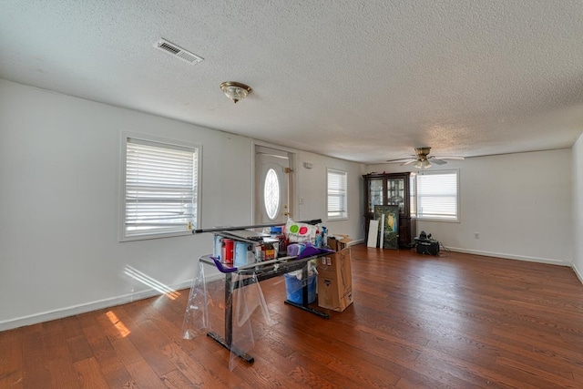 interior space with ceiling fan, a textured ceiling, and dark hardwood / wood-style flooring