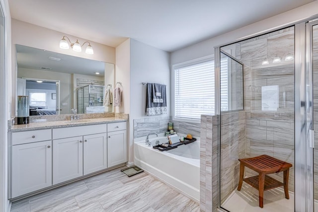 bathroom featuring vanity and shower with separate bathtub