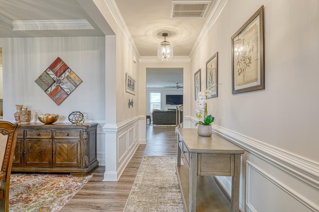 hall with wood-type flooring and ornamental molding