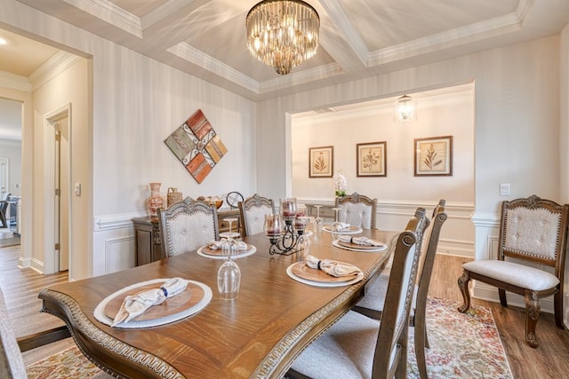 dining space with coffered ceiling, an inviting chandelier, ornamental molding, beam ceiling, and hardwood / wood-style floors