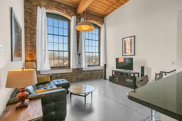 living room featuring beamed ceiling, brick wall, concrete flooring, and wooden ceiling