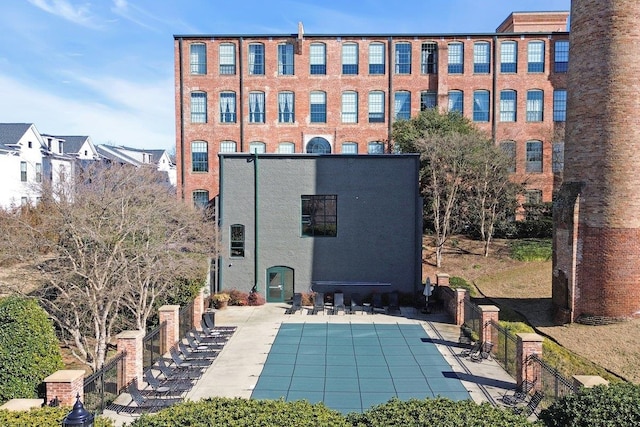 back of house featuring a community pool and a patio area