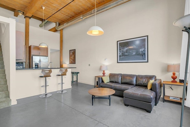 living room with a high ceiling, sink, wood ceiling, and beam ceiling