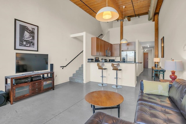 living room featuring beam ceiling, wood ceiling, and a towering ceiling