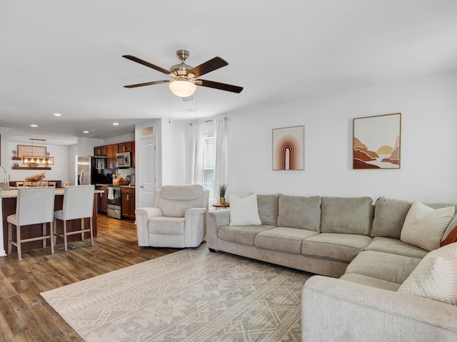 living room featuring sink, dark hardwood / wood-style floors, and ceiling fan