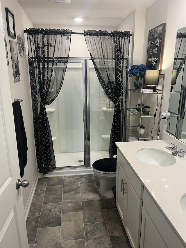 bathroom with an enclosed shower, vanity, and toilet