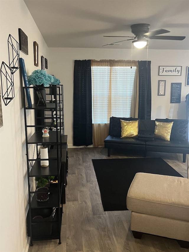 living room featuring dark wood-type flooring and ceiling fan