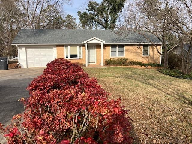 single story home with a garage and a front lawn