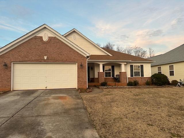 view of front of home featuring a yard, a garage, and a porch