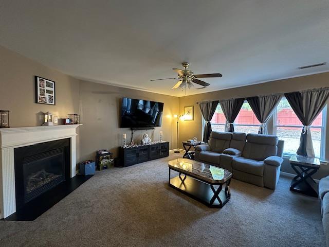 carpeted living room with ceiling fan