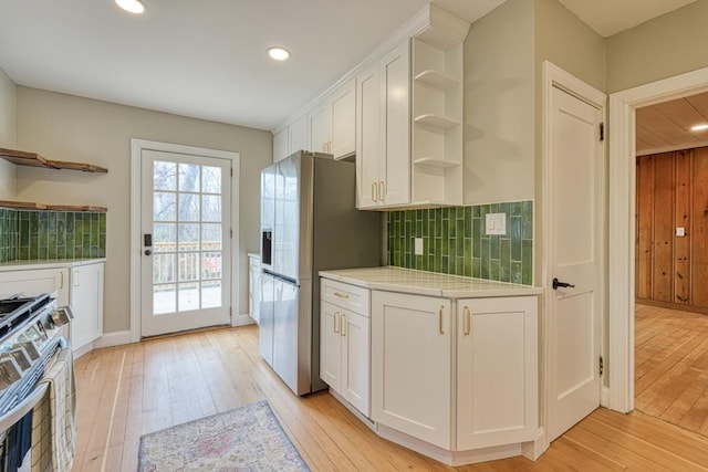 kitchen featuring tasteful backsplash, white cabinetry, appliances with stainless steel finishes, and light hardwood / wood-style floors