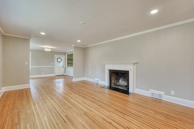 unfurnished living room featuring ornamental molding, a fireplace, and light wood-type flooring