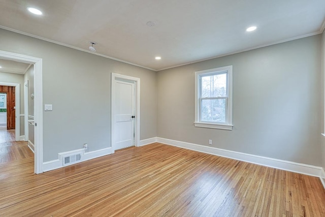 empty room featuring ornamental molding and light hardwood / wood-style flooring