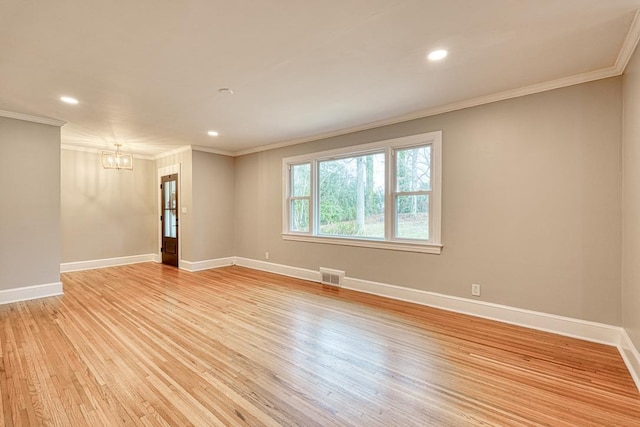 empty room with an inviting chandelier, ornamental molding, and light hardwood / wood-style flooring