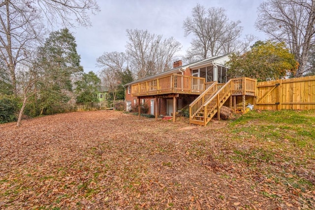 back of property with a wooden deck and a sunroom