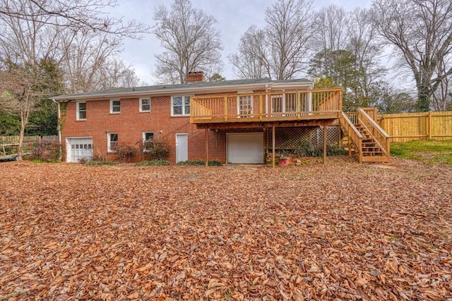 rear view of house featuring a garage and a deck