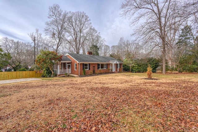 ranch-style house with covered porch and a front lawn