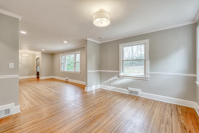 unfurnished room featuring ornamental molding and light hardwood / wood-style flooring