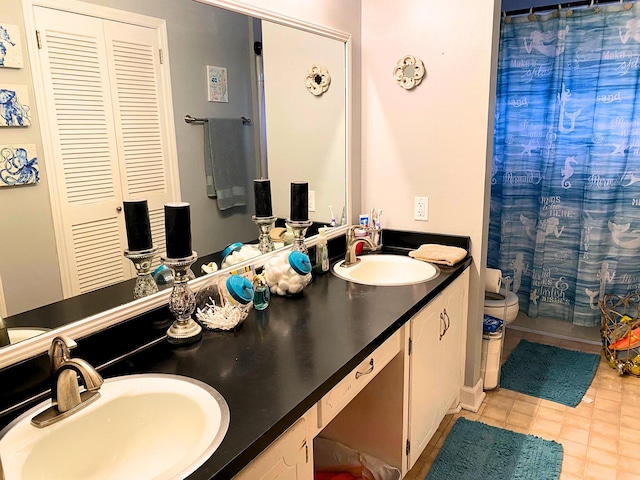 bathroom featuring vanity, tile patterned floors, and toilet