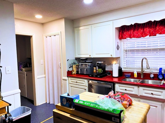 kitchen featuring washer and dryer, dishwasher, sink, white cabinets, and a textured ceiling