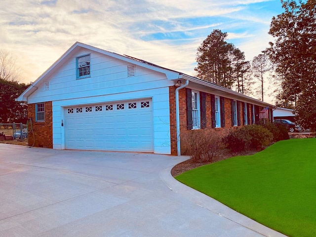 property exterior at dusk with a garage and a yard