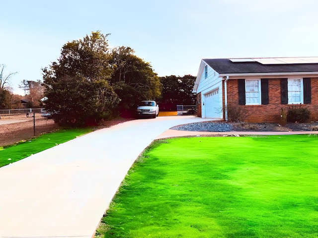 view of home's exterior with a garage, a lawn, and solar panels