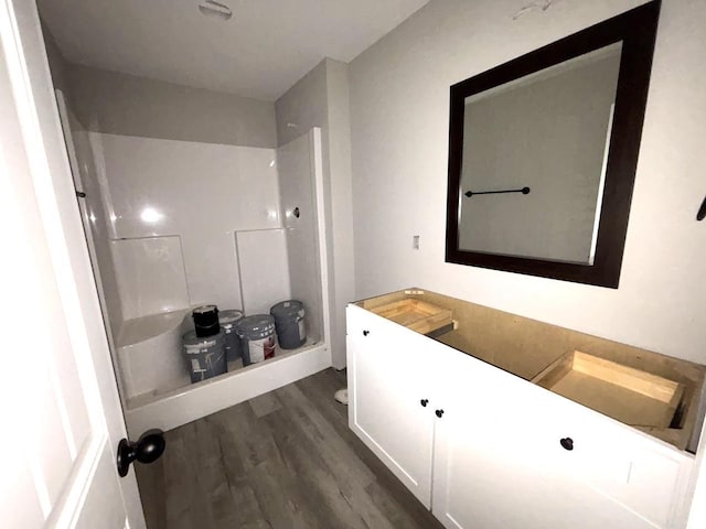 bathroom with a stall shower, wood finished floors, and vanity