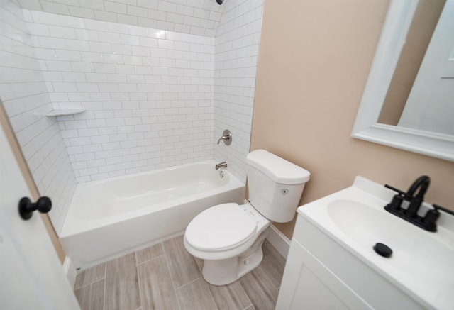 full bathroom with vanity, tiled shower / bath, and toilet