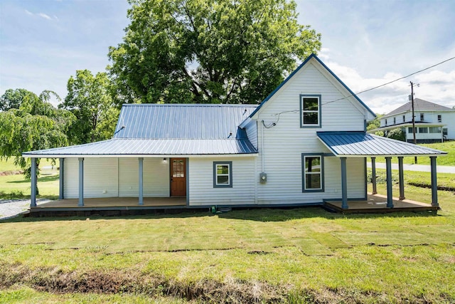 rear view of property with a porch and a yard