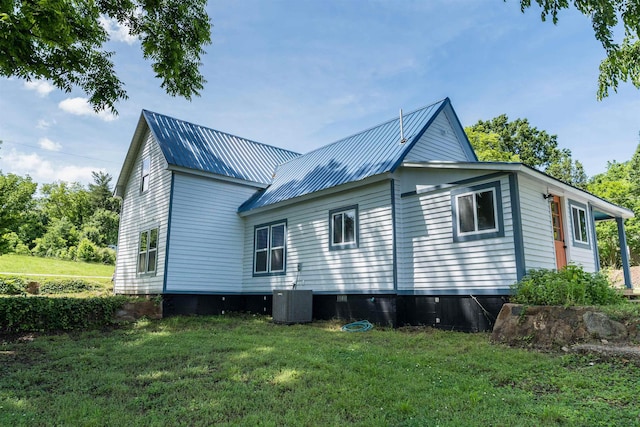 exterior space with cooling unit and a lawn