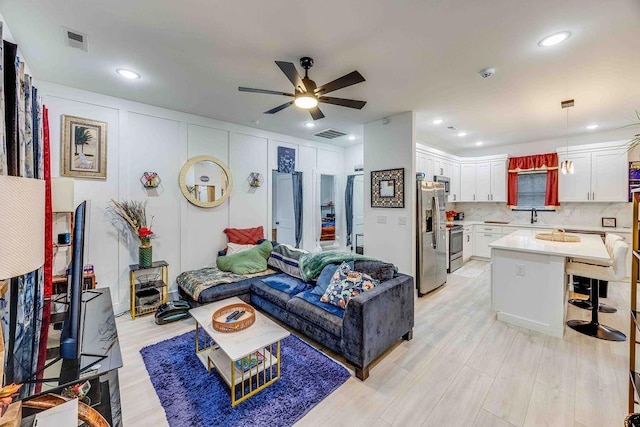 living room featuring sink and ceiling fan