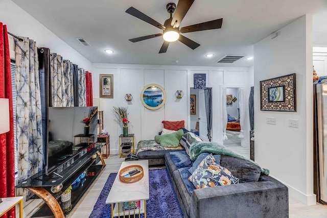 living room featuring ceiling fan and light hardwood / wood-style flooring