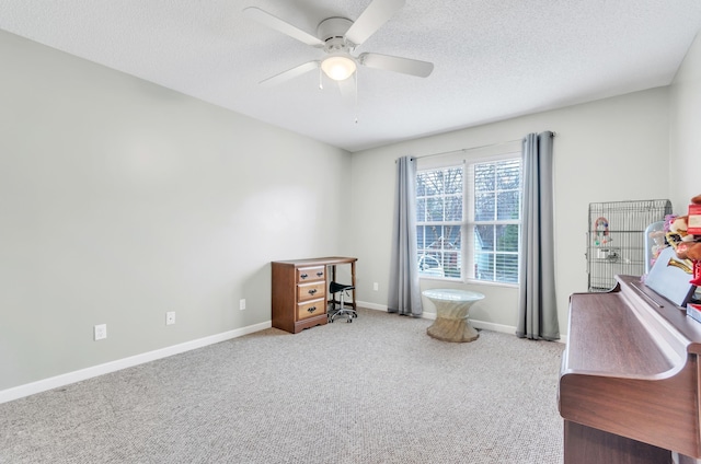 carpeted office space with a textured ceiling and ceiling fan