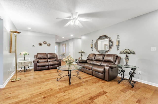 living room featuring a textured ceiling, light hardwood / wood-style floors, and ceiling fan