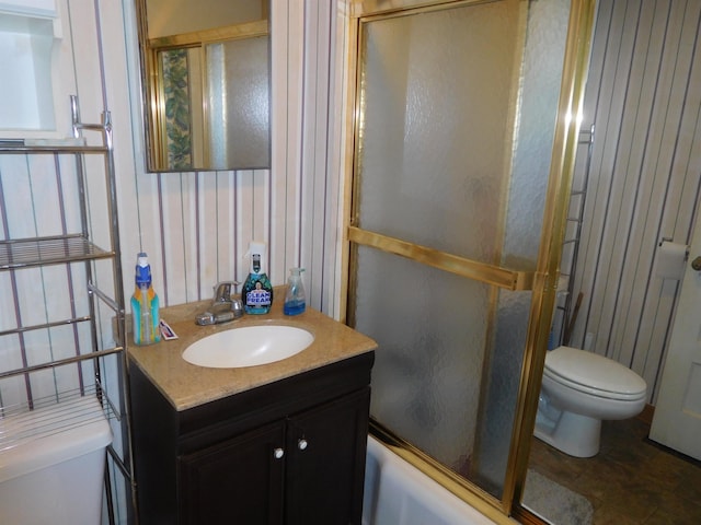 full bathroom with toilet, vanity, and bath / shower combo with glass door