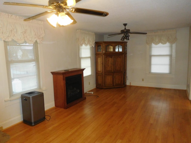 unfurnished living room with hardwood / wood-style flooring and ceiling fan