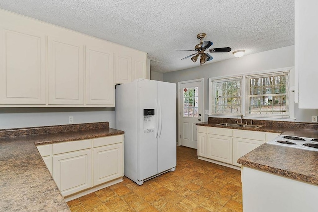 kitchen featuring sink, white cabinets, white fridge with ice dispenser, ceiling fan, and a textured ceiling