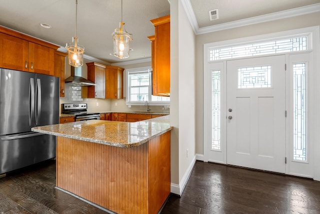 kitchen with wall chimney range hood, stainless steel appliances, light stone countertops, decorative light fixtures, and kitchen peninsula