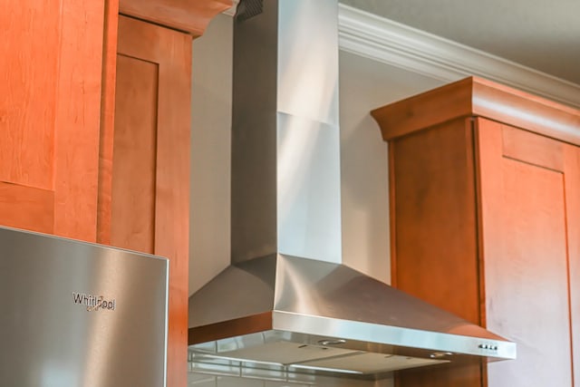 interior space featuring ornamental molding and wall chimney range hood