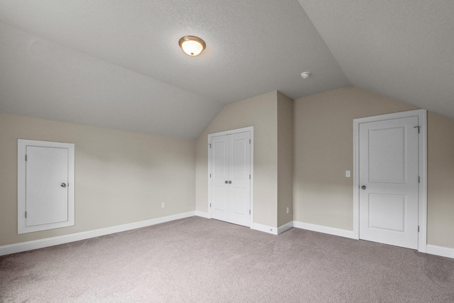 bonus room featuring lofted ceiling, carpet floors, and a textured ceiling