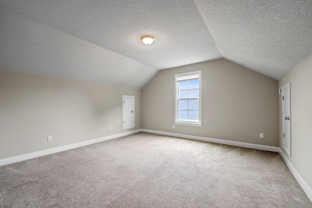 bonus room featuring lofted ceiling, carpet flooring, and a textured ceiling