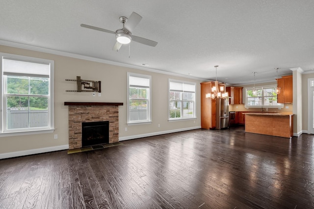 unfurnished living room featuring ornamental molding, a stone fireplace, dark hardwood / wood-style floors, and a textured ceiling