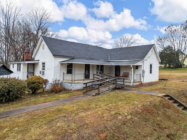 view of front of home with cooling unit, covered porch, and a front lawn