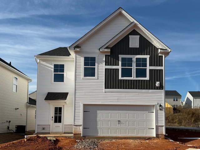 view of front facade with a garage and central AC