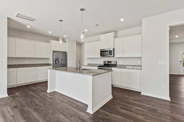 kitchen with sink, dark wood-type flooring, appliances with stainless steel finishes, a kitchen island with sink, and white cabinetry