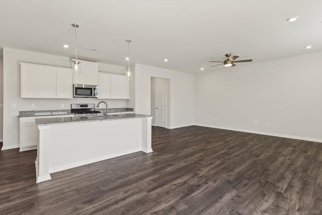 kitchen featuring pendant lighting, white cabinetry, a kitchen island with sink, stainless steel appliances, and light stone countertops