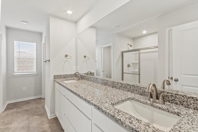 bathroom featuring vanity, a shower with shower door, and toilet